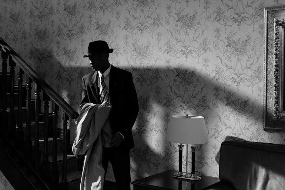 A black and white scene of a detective in a vintage interior, exuding mystery and intrigue.