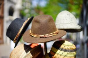 A vibrant display of fashionable fedoras stacked outdoors. Perfect for sun protection and style.