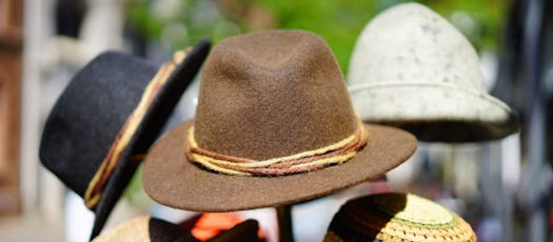 A vibrant display of fashionable fedoras stacked outdoors. Perfect for sun protection and style.